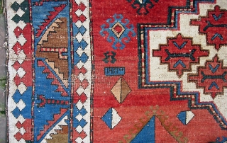 Kazak, 5.3 by 7.7. Circa 19th century.  Possibly Armenian with various inscriptions. There are two hot colors applied sparingly on one side of the rug.  Various old repairs and reweaves.  ...