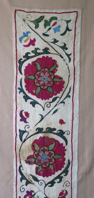 Antique Suzani fragment. Circa 19th Century. Mounted on cotton fabric. Size: 9.8" x 50.6"  25 cm x 129 cm.             