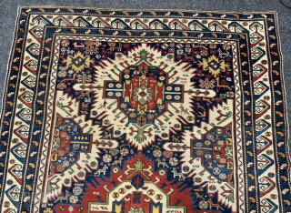 This 19th-century Caucasian Zeywa rug features a powerful geometric composition set against a deep midnight blue field. The central axis is defined by three monumental "sunburst" medallions, complemented by four halved medallions ...