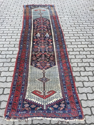 A lovely Persian Bakhtiary long rug displaying two cool looking gentlemen in the centre, size: ca. 345x100cm / 11'3''ft x 3'3''ft , signed and dated at the top. Sides and ends not  ...