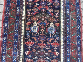 A lovely Persian Bakhtiary long rug displaying two cool looking gentlemen in the centre, size: ca. 345x100cm / 11'3''ft x 3'3''ft , signed and dated at the top. Sides and ends not  ...