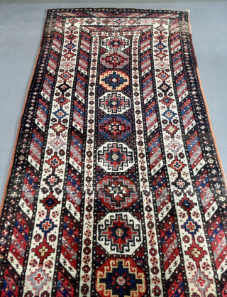 Offered here is an antique Caucasian long rug dating to the 19th century, measuring 325x125cm / 10,7ft by 4,1ft. The composition is centered around a vertical column of classic, stepped Memling guls, ...