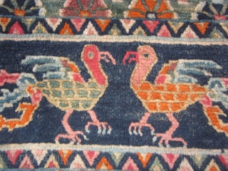 Tibetan table mat, with two facing chicken-like phoenixes, c.1930, 15 by 28 inches.                    