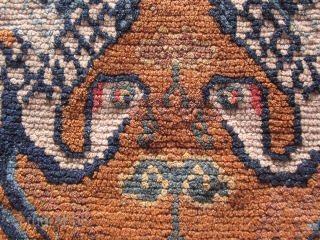 Tibetan mat with two facing (and charming) naïve phoenixes nibbling on the tree of life motif. A country piece 27 by 29 inches in very good condition. Perhaps made about 1920.  