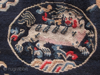 Tibetan: A pair of large mats, 32 by 36 inches, with prancing and naively drawn central snow lions surrounded by the "three Fruits" and a symbol of scholarly accomplishment. c.1930   