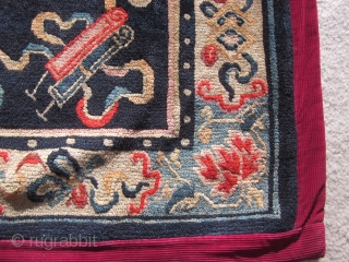 Tibetan: A pair of large mats, 32 by 36 inches, with prancing and naively drawn central snow lions surrounded by the "three Fruits" and a symbol of scholarly accomplishment. c.1930   