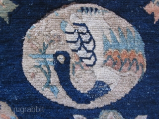 Tibetan sitting mat with phoenix in central rondel,fowers and wave border, about 2 by 2 ft, c.1930                