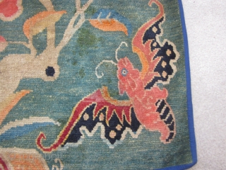 Tibetan mat with four gaily colored bats and a central lotus on an unusual and attractive green ground c.1920-30              