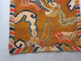Tibetan khaden, mid-20thC,34 by 64 inches, dramatic tiger (What was the weaver smoking?)flying through an orange/brown sky filled with cloudbands and flaming pearlsd          