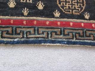 Tibetan : Table mat with two medallions, central endless knot motif, 1'3" by 3'. Some repair to lower border. c.1925             