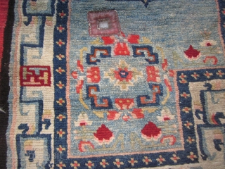 Tibetan notched saddle bottom, relatively uncrowded design on abrashed light blue field. Improvised border with small swastikas. Village product c.1930, very good condition. POR         