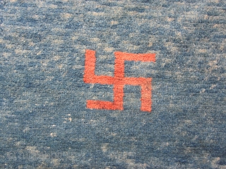 Tibetan khaden, 29 by 55 inches, three red swastikas on abrashed blue ground, natural dyes, pre-1900.                 