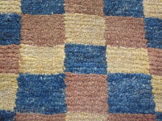 Tibetan, multi-colored checkerboard design in Wangden construction, but not for monastic use. About 1900, possibly before. Scattered small repairs. Size about 2 1/2 by 5 ft       