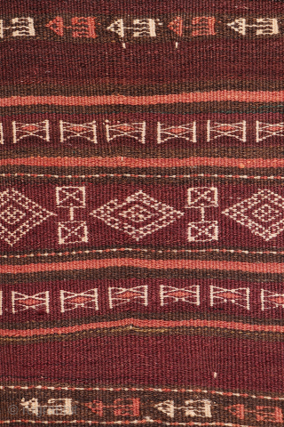 An earthy-toned (slightly aubergine hues) Serkhat Baluch Shaffi kilim with an exceptionally intricate pattern and refined drawing. The complexity of the design is achieved through the weaving of delicate linear motifs — ...