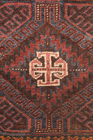An antique Baluch prayer rug from Afghanistan, featuring an elegant, dark palette of natural dyes, including a deep indigo blue. The field contains two medallions, whose distinctive cross-shaped interior motif is echoed ...