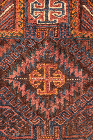 An antique Baluch prayer rug from Afghanistan, featuring an elegant, dark palette of natural dyes, including a deep indigo blue. The field contains two medallions, whose distinctive cross-shaped interior motif is echoed ...