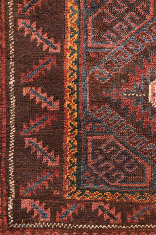 An antique Baluch prayer rug from Afghanistan, featuring an elegant, dark palette of natural dyes, including a deep indigo blue. The field contains two medallions, whose distinctive cross-shaped interior motif is echoed ...