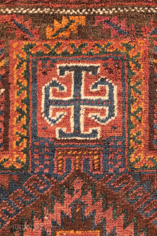 An antique Baluch prayer rug from Afghanistan, featuring an elegant, dark palette of natural dyes, including a deep indigo blue. The field contains two medallions, whose distinctive cross-shaped interior motif is echoed ...