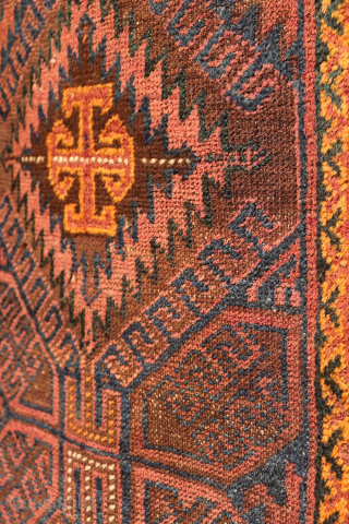 An antique Baluch prayer rug from Afghanistan, featuring an elegant, dark palette of natural dyes, including a deep indigo blue. The field contains two medallions, whose distinctive cross-shaped interior motif is echoed ...