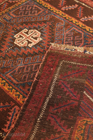 An antique Baluch prayer rug from Afghanistan, featuring an elegant, dark palette of natural dyes, including a deep indigo blue. The field contains two medallions, whose distinctive cross-shaped interior motif is echoed ...