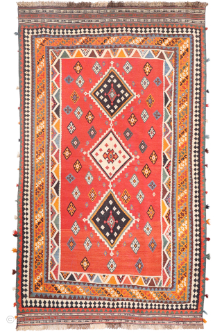 This antique Qashqai kilim is a striking example of tribal weaving, created with rich, naturally dyed colors that have retained their depth and vibrancy over time.

The main field features a bold deep-red  ...