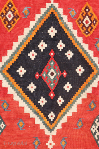 This antique Qashqai kilim is a striking example of tribal weaving, created with rich, naturally dyed colors that have retained their depth and vibrancy over time.

The main field features a bold deep-red  ...