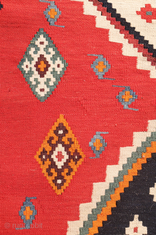 This antique Qashqai kilim is a striking example of tribal weaving, created with rich, naturally dyed colors that have retained their depth and vibrancy over time.

The main field features a bold deep-red  ...