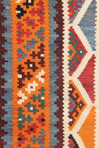 This antique Qashqai kilim is a striking example of tribal weaving, created with rich, naturally dyed colors that have retained their depth and vibrancy over time.

The main field features a bold deep-red  ...