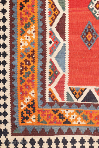 This antique Qashqai kilim is a striking example of tribal weaving, created with rich, naturally dyed colors that have retained their depth and vibrancy over time.

The main field features a bold deep-red  ...