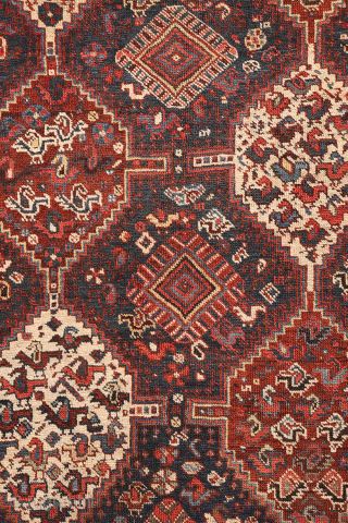 An antique Khamseh rug with a wonderful design and a very practical, almost square size.
The rug features two sets of medallions, each filled with numerous birds. These birds are repeated throughout the ...