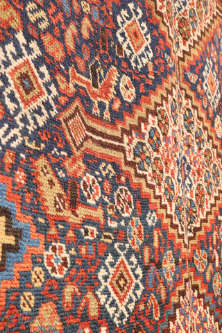 An antique Khamseh rug featuring three large medallions arranged horizontally, extending almost to the rug’s borders. The deep navy-blue field is richly decorated with birds, botehs, S-shaped motifs, and delicate vegetal elements.

The  ...