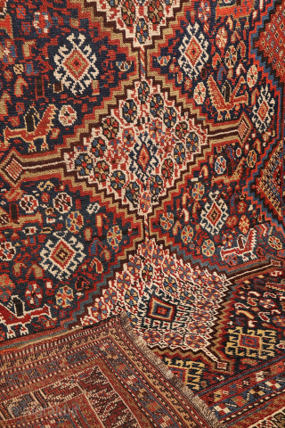 An antique Khamseh rug featuring three large medallions arranged horizontally, extending almost to the rug’s borders. The deep navy-blue field is richly decorated with birds, botehs, S-shaped motifs, and delicate vegetal elements.

The  ...