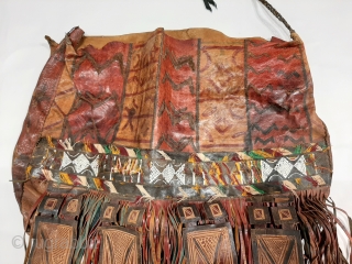 Tuareg leather womans travel bag ("aghrig"), with hand worked and dyed leather, probably goat skin. Intricate leather work with check pattern cut into dyed skin and embroidered thread patterns. The green dyed  ...