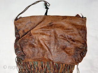 Tuareg leather womans travel bag ("aghrig"), with hand worked and dyed leather, probably goat skin. Intricate leather work with check pattern cut into dyed skin and embroidered thread patterns. The green dyed  ...