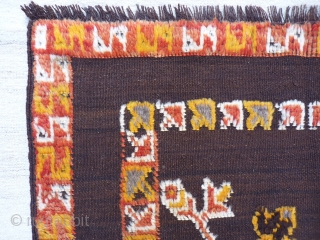 Small Berber kilim with piled motifs and borders, possibly a horse cover, 105x110cms, undyed dark brown wool field, very good condition.            