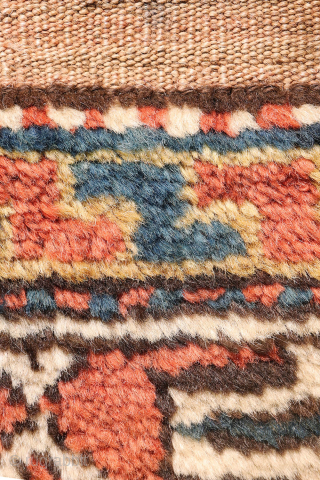 A North West Persian Kurdish rug featuring an oversized design with a large octagon placed in each corner. The central field contains smaller secondary motifs, creating a structured yet lively arrangement.

While the  ...