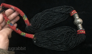 Tribal antique woman necklace from Indus
kohistan valley of Pakistan. The central large bead is silver
while the numerous strands of black beads are glass beads.         