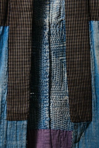 This is a boro sashiko sodenashi, a type of sleeveless hanten, or jacket, typically worn by Japanese farmers. 

The outer fabrics are comprised of solid indigo cotton. A kasuri yoke and lapel  ...