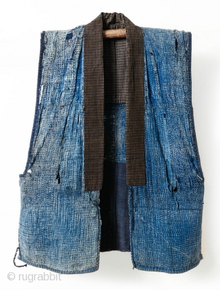 This is a boro sashiko sodenashi, a type of sleeveless hanten, or jacket, typically worn by Japanese farmers. 

The outer fabrics are comprised of solid indigo cotton. A kasuri yoke and lapel  ...