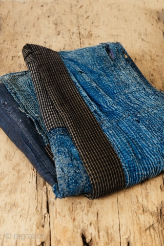 This is a boro sashiko sodenashi, a type of sleeveless hanten, or jacket, typically worn by Japanese farmers. 

The outer fabrics are comprised of solid indigo cotton. A kasuri yoke and lapel  ...