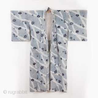 This is a shibori yukata. The shibori process is arashi shibori, where the cloth is wrapped around a pole and then dyed. Then the cloth was further dyed via katazome. The floral  ...