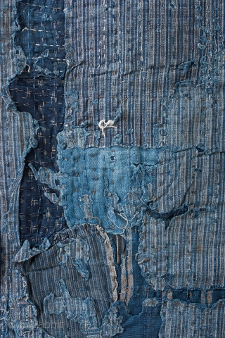 This is a large, heavily patched fragment of a Japanese boro futon cover. There are over sixty pieces of cloth on this textile, which have been sashiko stitched on top of one  ...