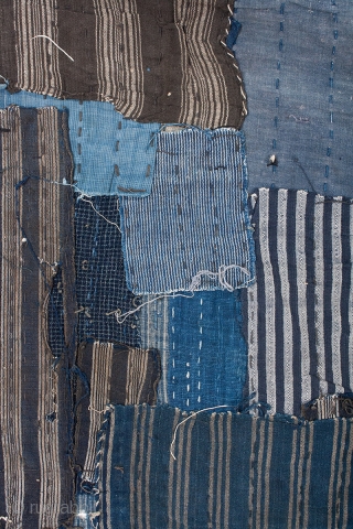 This is a large, heavily patched fragment of a Japanese boro futon cover. There are over sixty pieces of cloth on this textile, which have been sashiko stitched on top of one  ...