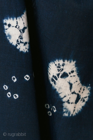 This is a vintage Japanese cotton textile fragment decorated with mixed shibori tie-dye techniques of kanoko (spaced dots), boshi (capped circles), and shapes, perhaps of fundo weights. The pattern is relaxed and  ...