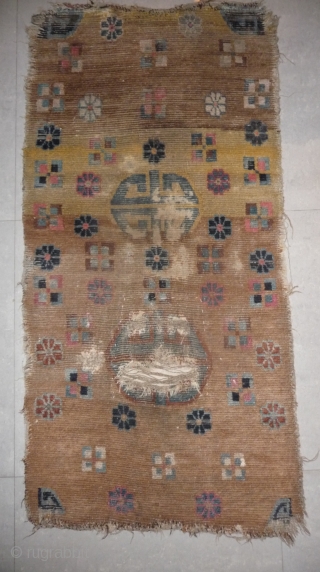 an unusual appealing big tibetan sleeping and/or meditation rug with a totemic like so called shou design and abrashed ground in yellow and brown. what is now called shou design has been  ...