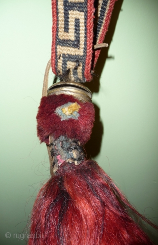 very nice tibetan animal amulet-trapping with cast bell . the band is woven in wool, the bobble under the bell is made of  red-dyed yak hair. the end is a red-dyed  ...