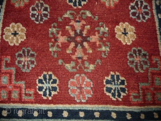 an antique tibetan khaden in superb condition. multicolored lotus flower on a fantastic red background color, beautiful red green border, superb wool and unusual medaillion drawing. the slightly white spot visible on  ...