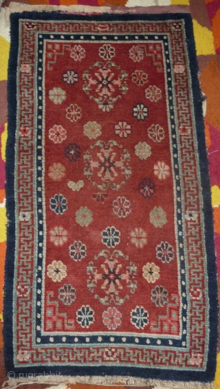 an antique tibetan khaden in superb condition. multicolored lotus flower on a fantastic red background color, beautiful red green border, superb wool and unusual medaillion drawing. the slightly white spot visible on  ...