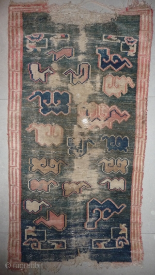 all about clouds. an early 20th century tibetan popart rug with an abrashed green sky background. damage but a funny unique piece; note the integration of a cloud design in the traditional  ...