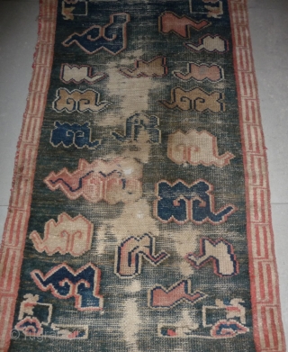 all about clouds. an early 20th century tibetan popart rug with an abrashed green sky background. damage but a funny unique piece; note the integration of a cloud design in the traditional  ...